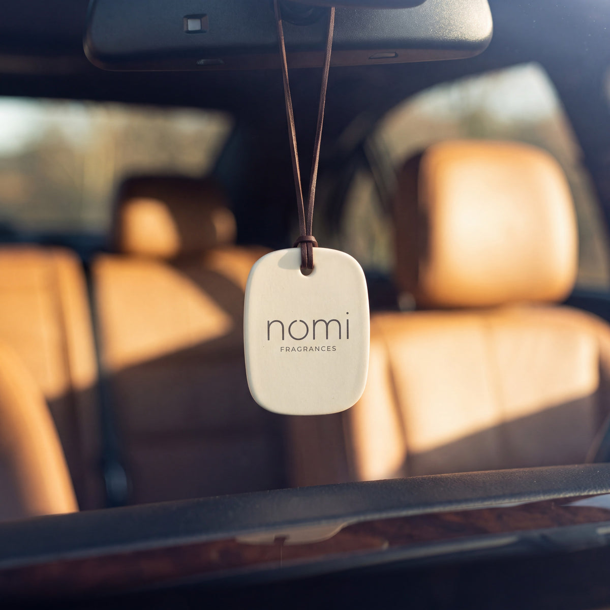 nomi car diffuser hanging from a rear-view mirror