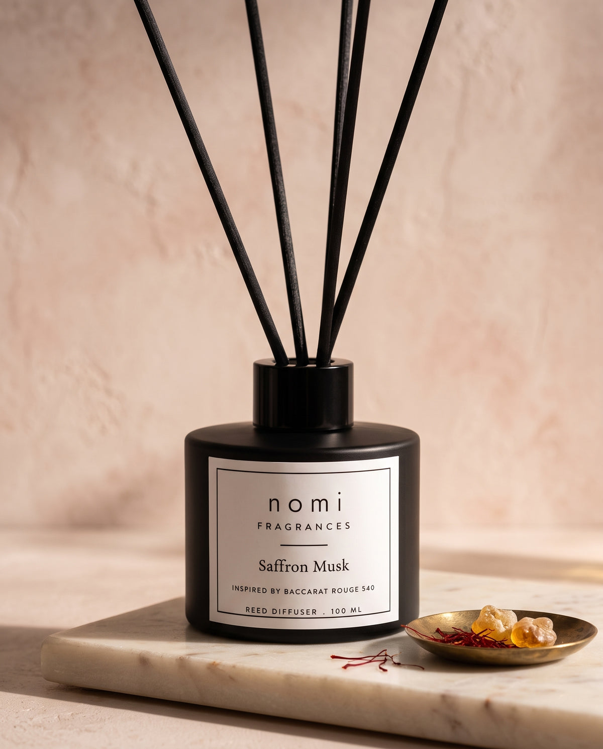 Saffron Musk reed diffuser round bottle close-up with saffron threads and amber